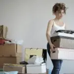 Meaning and Examples Of Personal And Family Resources for Primary 5 2 Uses Of Personal And Family Resources: A young woman carrying boxes during a move into a new apartment, surrounded by packed belongings.