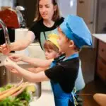 The Roles Of The Children In The Family and Family Tree for Primary 5 2 Roles Of The Children In The Family: Mother and children wearing chef hats washing hands while preparing food together in the kitchen.